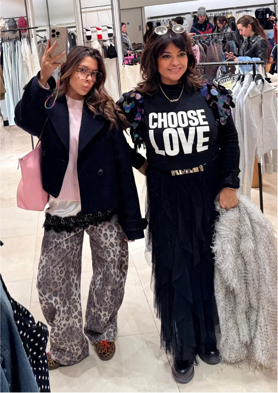 Nishma and Anushka in a clothes shop, Anushka taking a mirror selfie